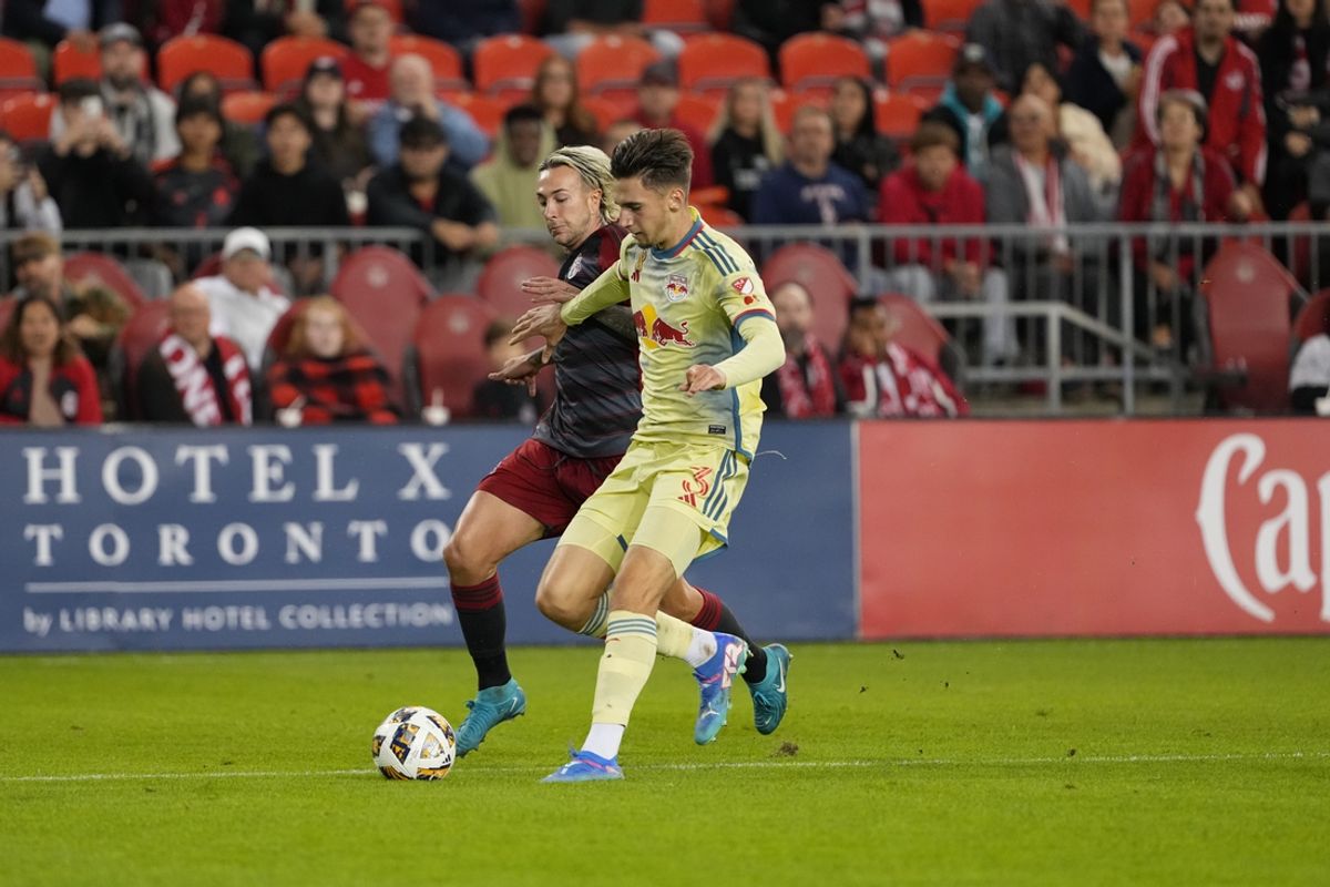 Oct 2, 2024; Toronto, Ontario, CAN; Toronto FC forward Federico Bernardeschi (10) plays the ball defended by New York Red Bulls defender Noah Eile (3) in the first half at BMO Field. Mandatory Credit: Nick Turchiaro-Imagn Images