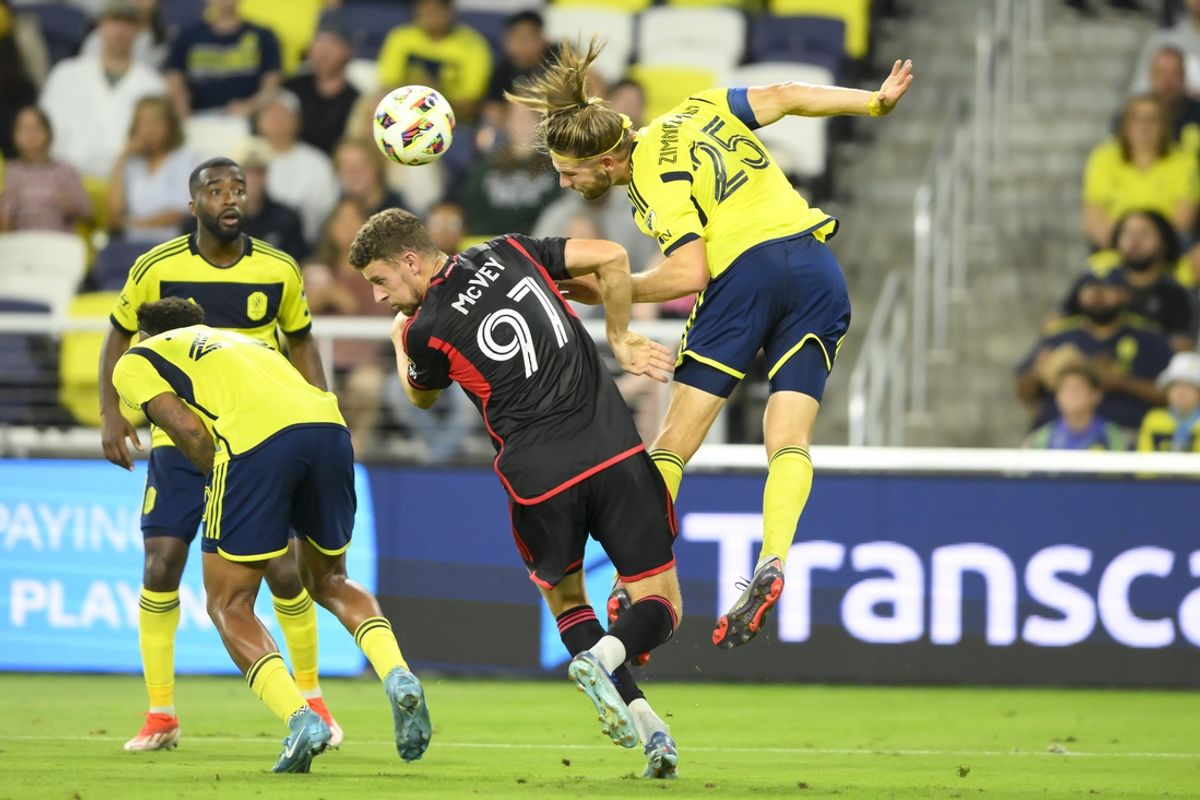 Oct 2, 2024; Nashville, Tennessee, USA;  Nashville SC defender Walker Zimmerman (25) heads the ball  over D.C. United defender Christopher McVey (97) during the first half at Geodis Park. Mandatory Credit: Steve Roberts-Imagn Images