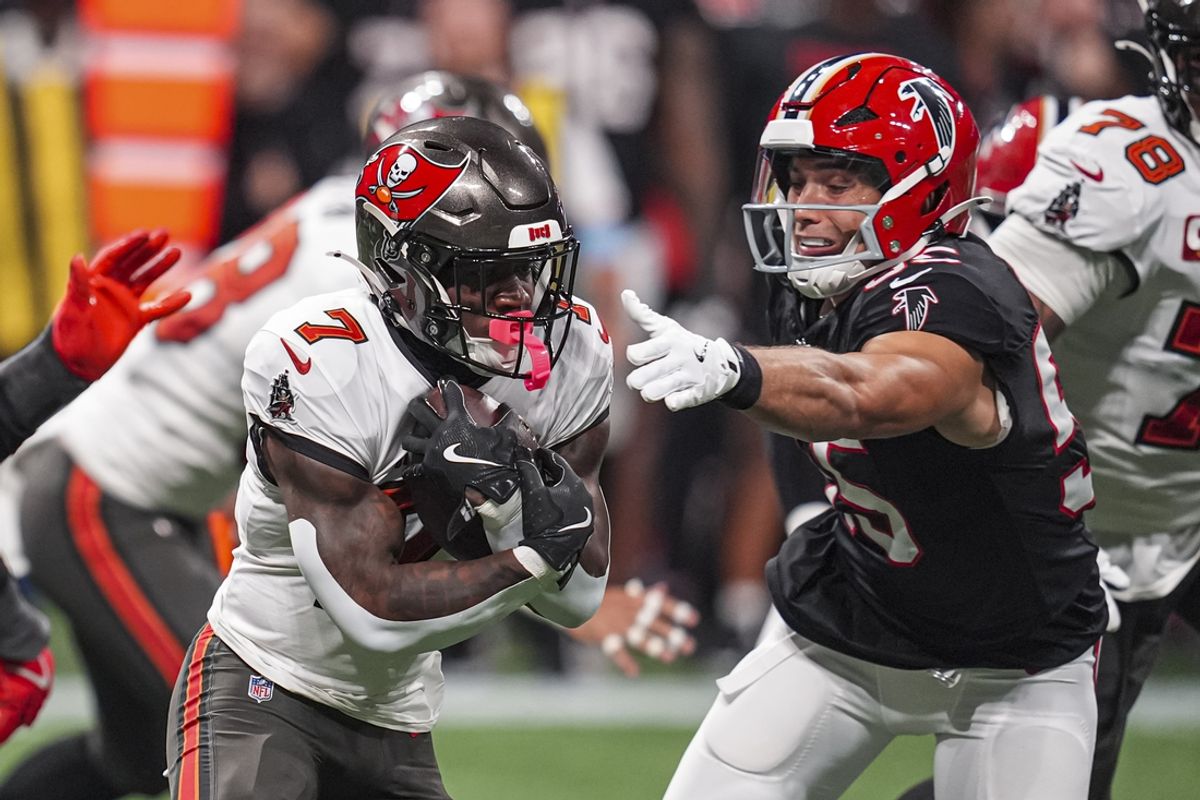 Oct 3, 2024; Atlanta, Georgia, USA; Tampa Bay Buccaneers running back Bucky Irving (7) runs against Atlanta Falcons linebacker Kaden Elliss (55) during the first half at Mercedes-Benz Stadium. Mandatory Credit: Dale Zanine-Imagn Images