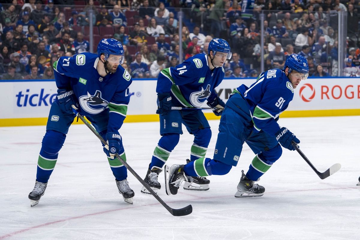 Oct 4, 2024; Vancouver, British Columbia, CAN; Vancouver Canucks defenseman Derek Forbort (27) and forward Jake DeBrusk (74) and forward Daniel Sprong (91) during a face-off against the Edmonton Oilers during the second period at Rogers Arena. Mandatory Credit: Bob Frid-Imagn Images