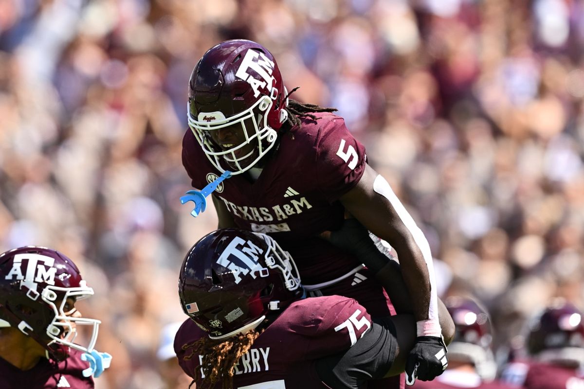 Oct 5, 2024; College Station, Texas, USA; Texas A&M Aggies offensive lineman Kam Dewberry (75) hoists running back Amari Daniels (5) after scoring a touchdown in the second quarter against the Missouri Tigers at Kyle Field. Mandatory Credit: Maria Lysaker-Imagn Images.