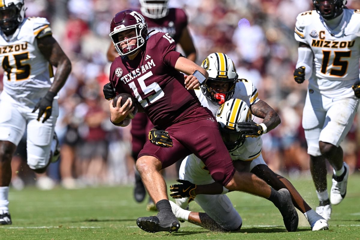 Oct 5, 2024; College Station, Texas, USA; Texas A&M Aggies quarterback Conner Weigman (15) is tackled by Missouri Tigers wide receiver Luther Burden III (3) in the second quarter at Kyle Field. Mandatory Credit: Maria Lysaker-Imagn Images.