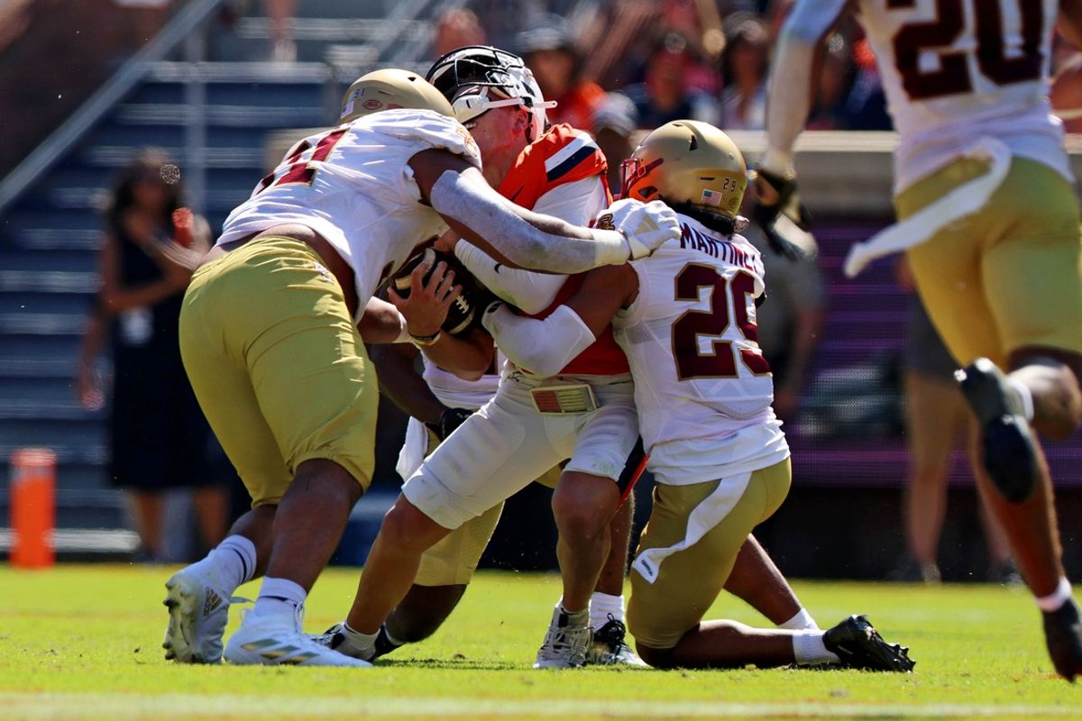 Oct 5, 2024; Charlottesville, Virginia, USA; Virginia Cavaliers quarterback Anthony Colandrea (10) is tackled by Boston College Eagles defensive back Cameron Martinez (29) during the second quarter at Scott Stadium. Mandatory Credit: Peter Casey-Imagn Images
