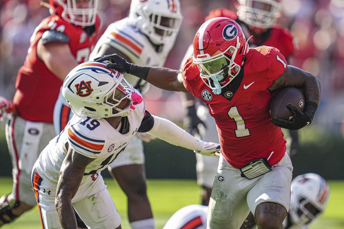 Oct 5, 2024; Athens, Georgia, USA; Georgia Bulldogs running back Trevor Etienne (1) delivers a straight arm to Auburn Tigers safety Sylvester Smith (19) during the first half at Sanford Stadium. Mandatory Credit: Dale Zanine-Imagn Images