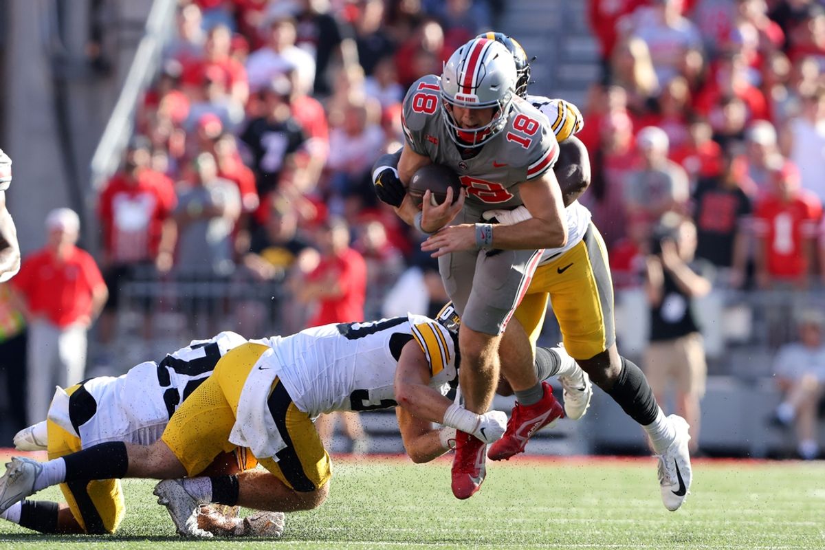 Oct 5, 2024; Columbus, Ohio, USA; Ohio State Buckeyes quarterback Will Howard (18) dives for a first down against Iowa Hawkeyes defensive back Quinn Schulte (30) during the second quarter at Ohio Stadium. Mandatory Credit: Joseph Maiorana-Imagn Images