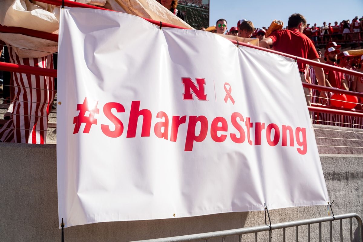 Oct 5, 2024; Lincoln, Nebraska, USA; A sign supporting Nebraska Cornhuskers announcer Greg Sharpe hangs in the stadium before a game against the Rutgers Scarlet Knights at Memorial Stadium. Mandatory Credit: Dylan Widger-Imagn Images