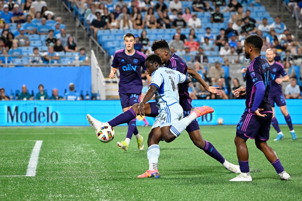 Oct 5, 2024; Charlotte, North Carolina, USA; CF Montreal forward Sunusi Ibrahim (14) shoots as Charlotte FC defender Adilson Malanda (29) and defender Nathan Byrne (14) defend in the first half at Bank of America Stadium. Mandatory Credit: Bob Donnan-Imagn Images