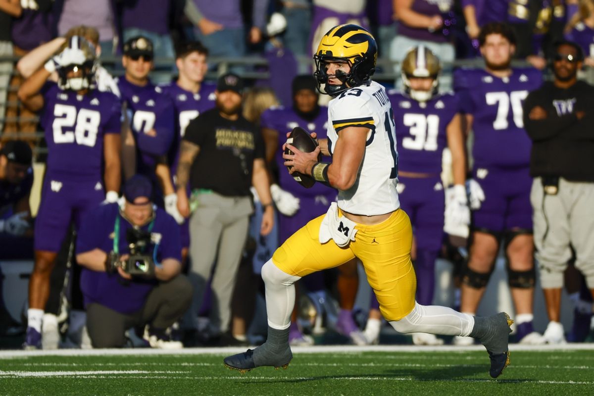 Oct 5, 2024; Seattle, Washington, USA; Michigan Wolverines quarterback Jack Tuttle (13) rushes against the Washington Huskies during the second quarter at Alaska Airlines Field at Husky Stadium.