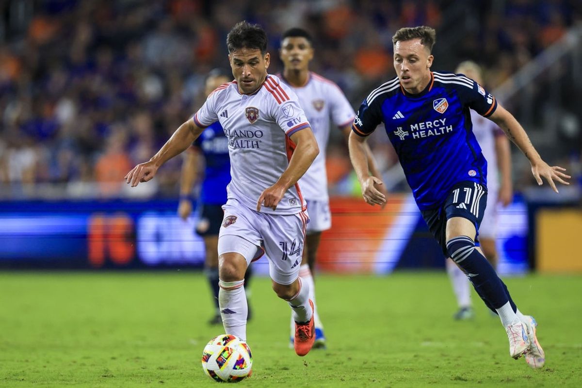 Oct 5, 2024; Cincinnati, Ohio, USA; Orlando City SC midfielder Nico Lodeiro (14) dribbles against FC Cincinnati forward Corey Baird (11) in the second half at TQL Stadium. Mandatory Credit: Katie Stratman-Imagn Images