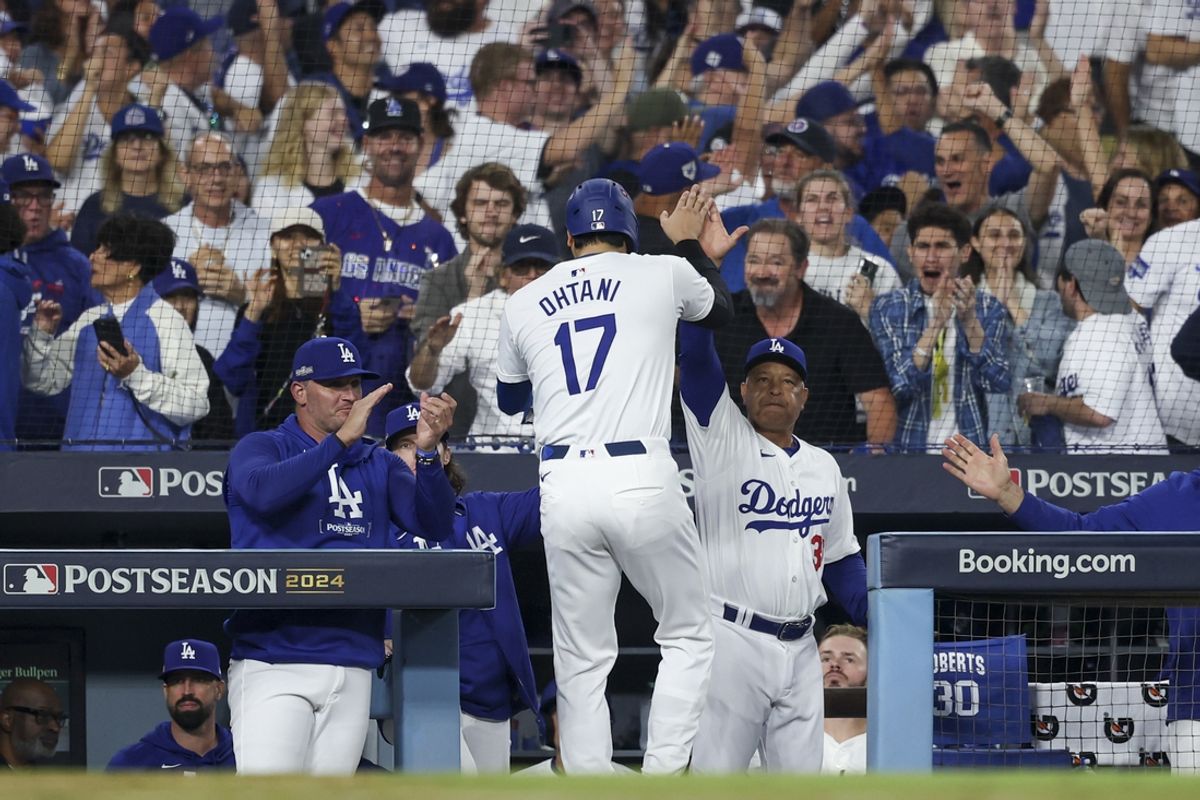 Oct 5, 2024; Los Angeles, California, USA; Los Angeles Dodgers designated hitter Shohei Ohtani (17) celebrates with manager Dave Roberts (30) after scoring a run against the San Diego Padres in the fifth inning during game one of the NLDS for the 2024 MLB Playoffs at Dodger Stadium. Mandatory Credit: Kiyoshi Mio-Imagn Images