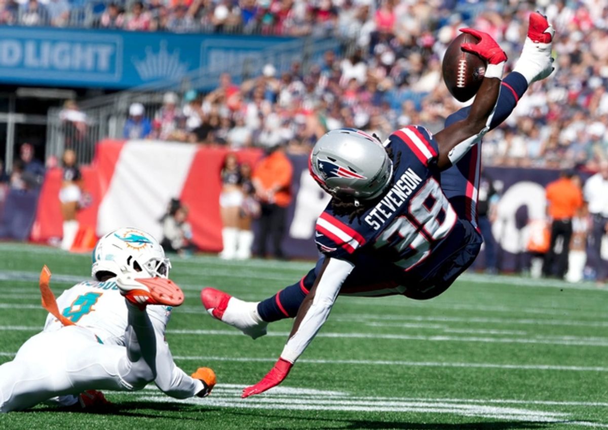 New England running back Rhamondre Stevenson get knocked off his feet by Dolphin Kader Kohou in the first half.