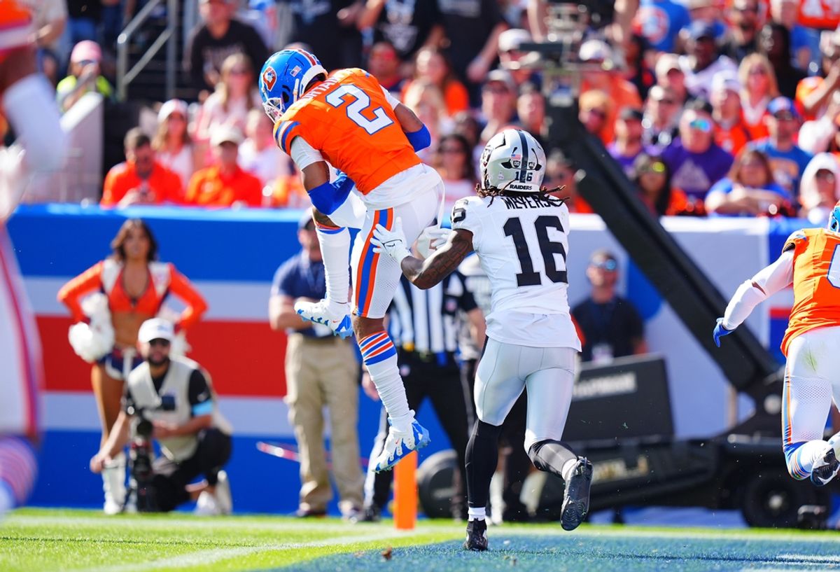 Oct 6, 2024; Denver, Colorado, USA; Denver Broncos cornerback Pat Surtain II (2) pulls in a interception intended for Las Vegas Raiders wide receiver Jakobi Meyers (16) in the second quarter at Empower Field at Mile High. Mandatory Credit: Ron Chenoy-Imagn Images