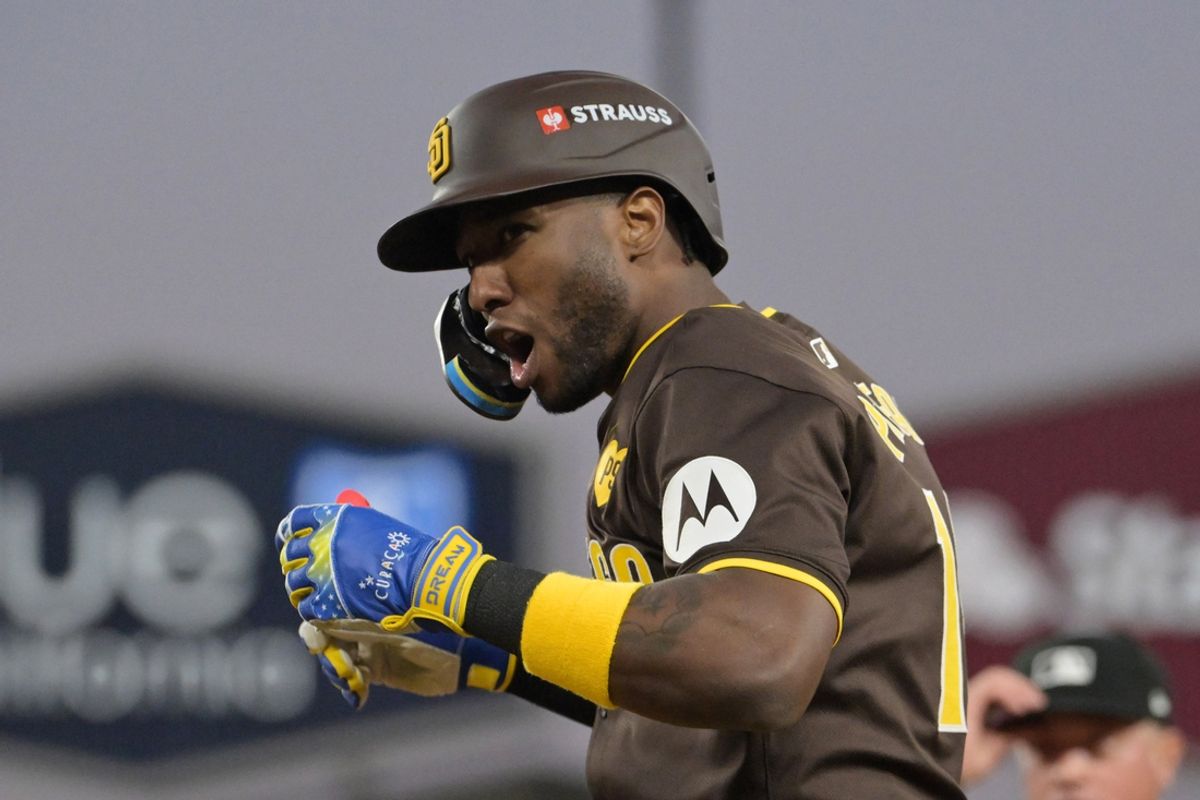 Oct 6, 2024; Los Angeles, California, USA; San Diego Padres outfielder Jurickson Profar (10) reacts at first base after bunting in the sixth inning against the Los Angeles Dodgers during game two of the NLDS for the 2024 MLB Playoffs at Dodger Stadium. Mandatory Credit: Jayne Kamin-Oncea-Imagn Images