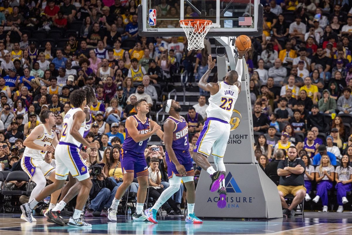 Oct 6, 2024; Palm Desert, California, USA; Los Angeles Lakers forward LeBron James (23) shoots a layup over Phoenix Suns guard Devin Booker (1) during the first half at Acrisure Arena. Mandatory Credit: David Frerker-Imagn Images