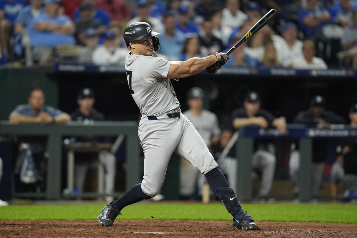 Oct 9, 2024; Kansas City, Missouri, USA; New York Yankees designated hitter Giancarlo Stanton (27) hits a single in the sixth inning against the Kansas City Royals during game three of the NLDS for the 2024 MLB Playoffs at Kauffman Stadium. Mandatory Credit: Jay Biggerstaff -Imagn Images