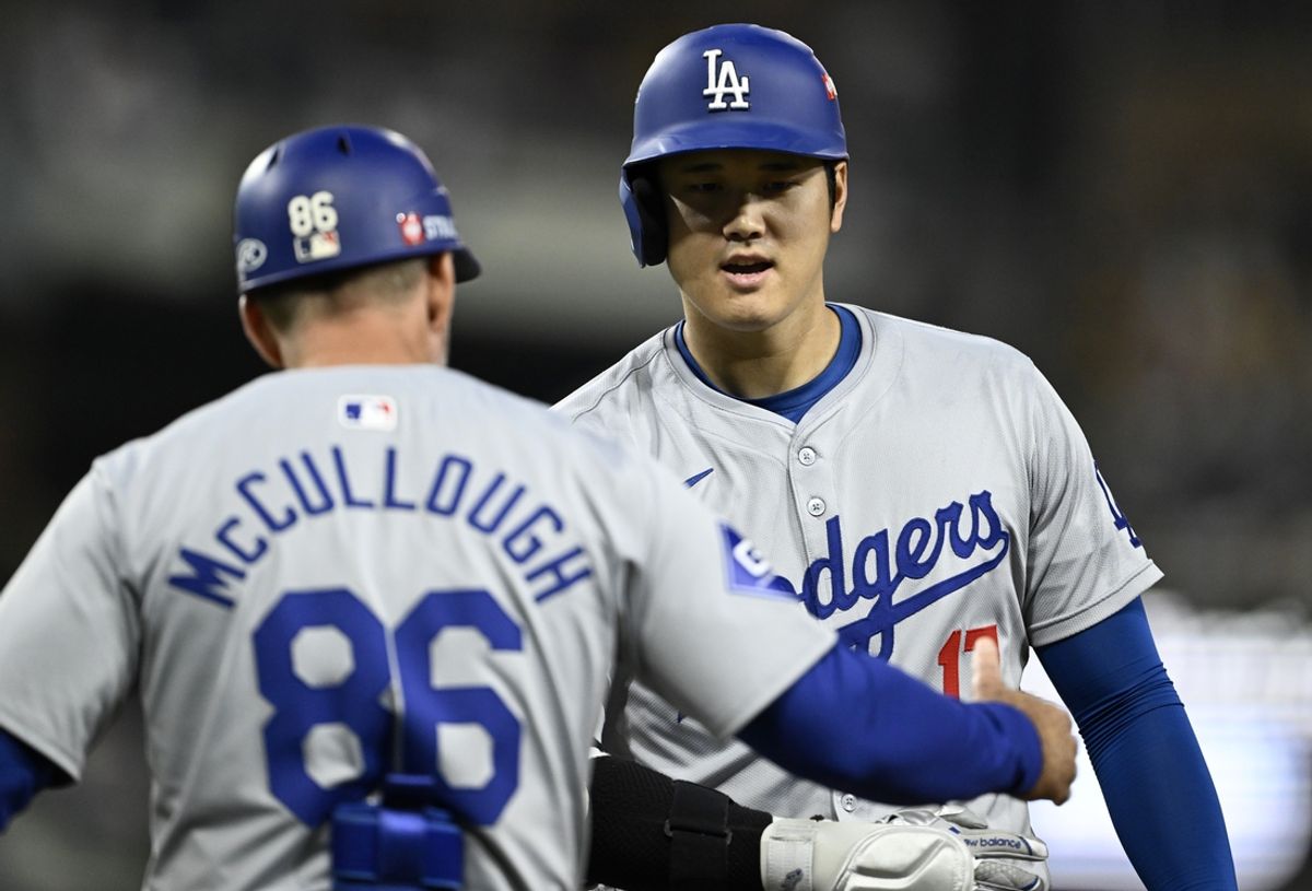 Oct 9, 2024; San Diego, California, USA; Los Angeles Dodgers designated hitter Shohei Ohtani (17) celebrates with first base coach Clayton McCullough (86) after hitting a RBI single in the second inning against the San Diego Padres during game four of the NLDS for the 2024 MLB Playoffs at Petco Park.  Mandatory Credit: Denis Poroy-Imagn Images