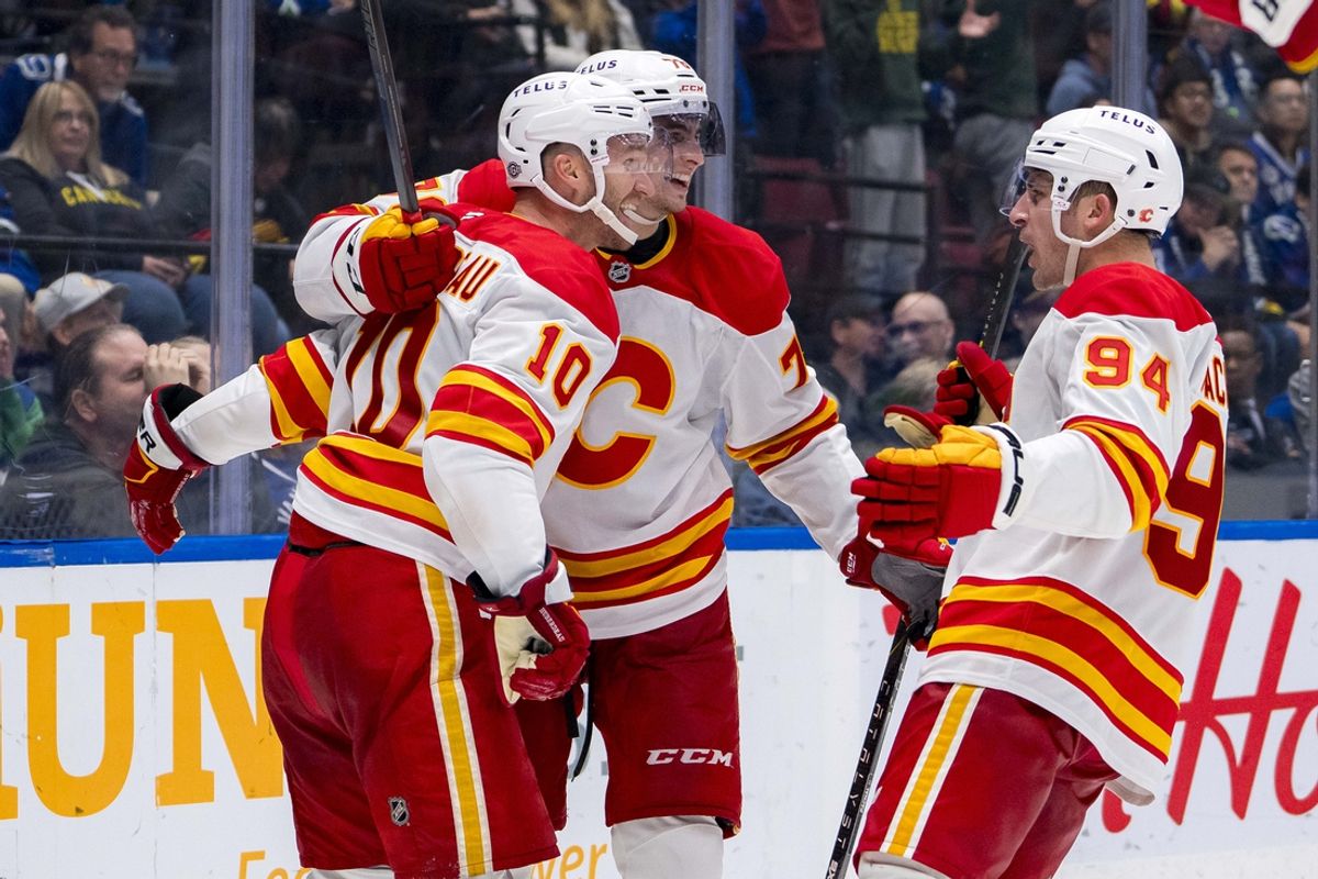 Oct 9, 2024; Vancouver, British Columbia, CAN; Calgary Flames forward Jonathan Huberdeau (10) and forward Martin Pospisil (76) and defenseman Brayden Pachal (94) celebrate Huberdeau’s goal against the Vancouver Canucks during the third period at Rogers Arena. Mandatory Credit: Bob Frid-Imagn Images