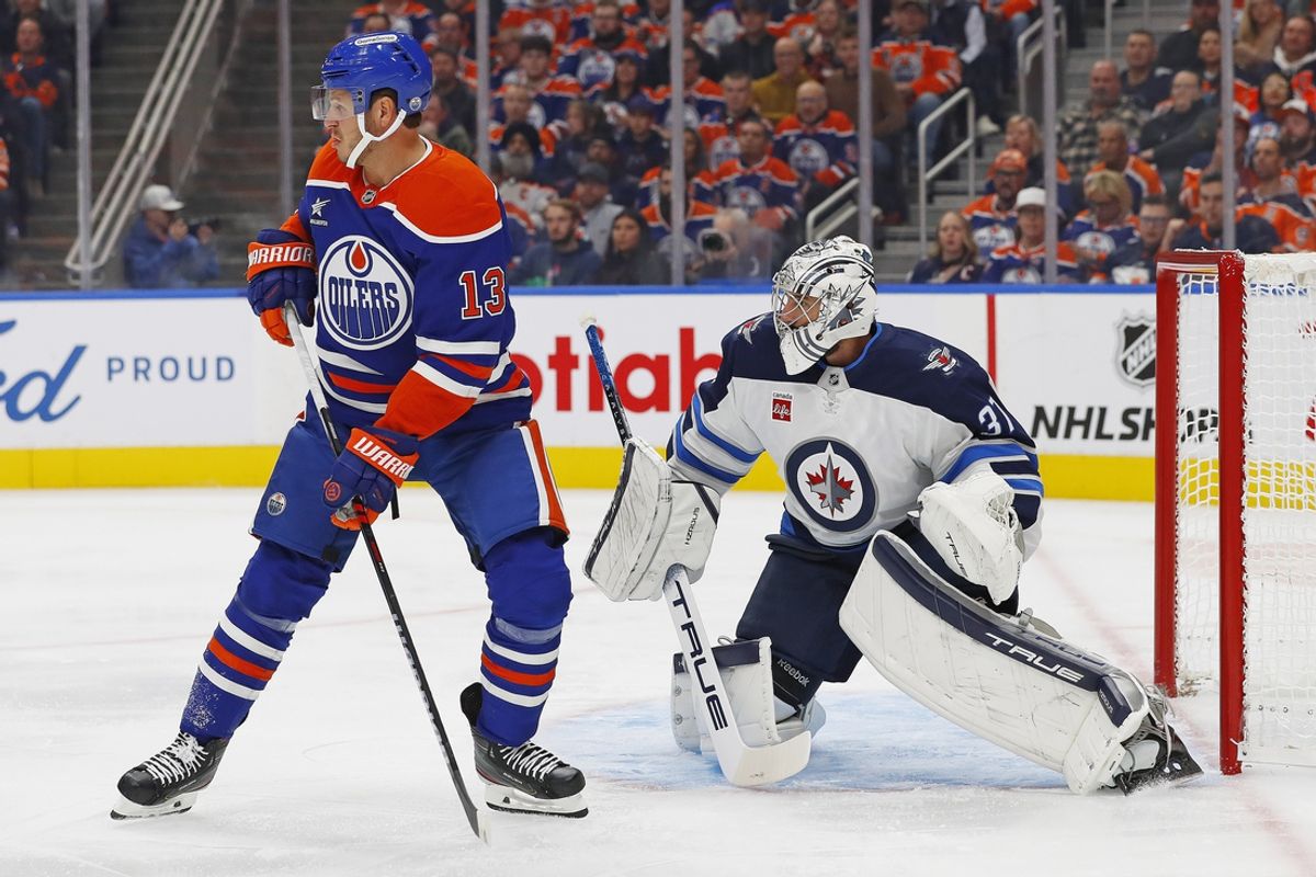 Oct 9, 2024; Edmonton, Alberta, CAN; Edmonton Oilers forward Mattias Janmark (13) tries to screen Winnipeg Jets goaltender Connor Hellebuyck (37) during the first period at Rogers Place. Mandatory Credit: Perry Nelson-Imagn Images