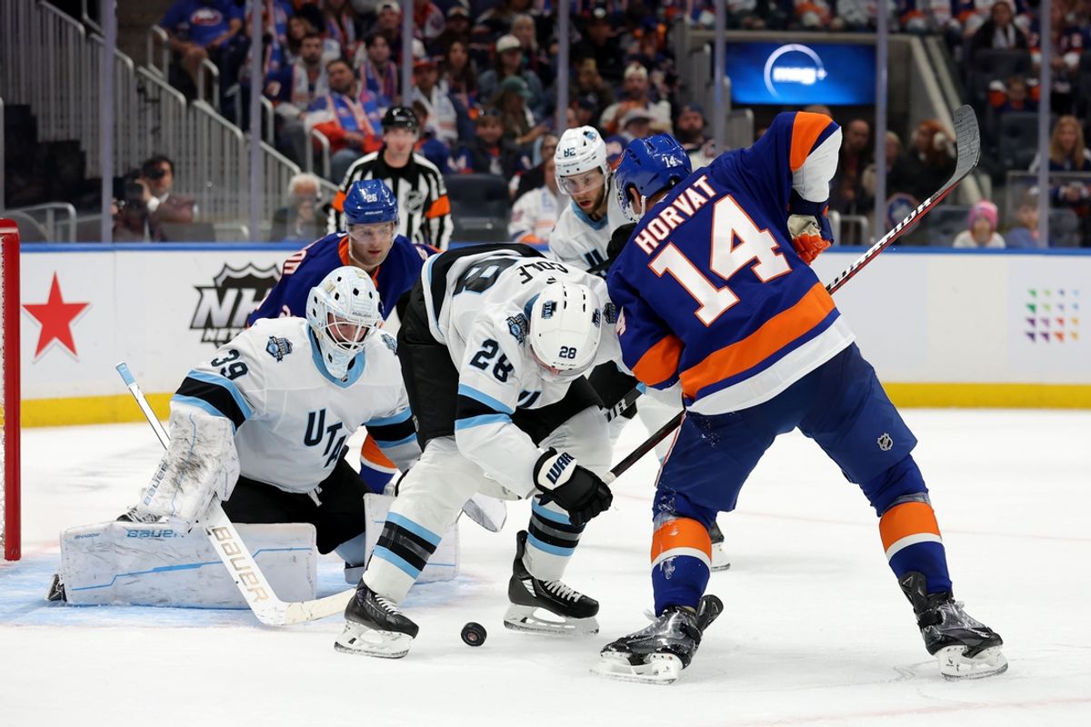 Oct 10, 2024; Elmont, New York, USA; New York Islanders center Bo Horvat (14) and Utah Hockey Club defenseman Ian Cole (28) fight for the puck in front of Utah goaltender Connor Ingram (39) during the second period at UBS Arena. Mandatory Credit: Brad Penner-Imagn Images