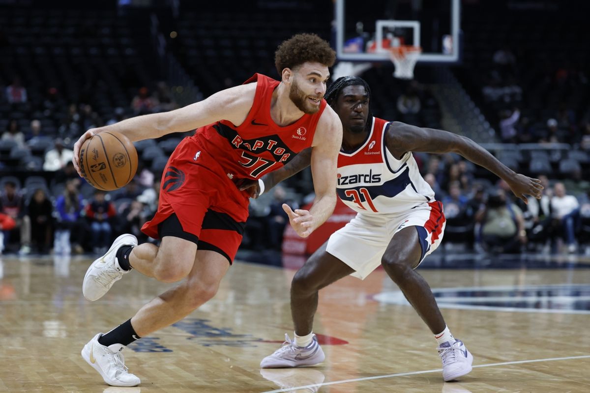 Oct 11, 2024; Washington, District of Columbia, USA; Toronto Raptors forward Jamison Battle (77) drives to the basket as Washington Wizards guard Kira Lewis Jr. (31) defends in the fourth quarter at Capital One Arena. Mandatory Credit: Geoff Burke-Imagn Images