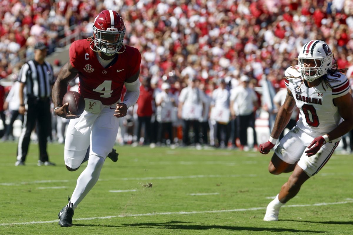 Oct 12, 2024; Tuscaloosa, Alabama, USA;  Alabama Crimson Tide quarterback Jalen Milroe (4) carries the ball in for a touchdown as South Carolina Gamecocks linebacker Debo Williams (0) defends during the first half at Bryant-Denny Stadium. Mandatory Credit: Butch Dill-Imagn Images