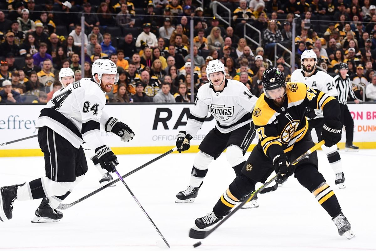 Oct 12, 2024; Boston, Massachusetts, USA;  Los Angeles Kings defenseman Vladislav Gavrikov (84) tries to poke the puck away from Boston Bruins center Mark Kastelic (47) during the first period at TD Garden. Mandatory Credit: Bob DeChiara-Imagn Images