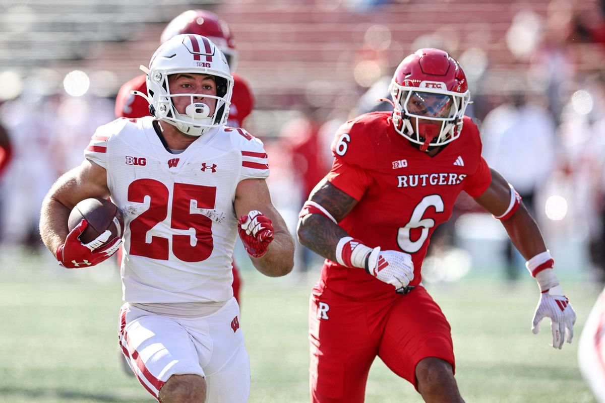 Oct 12, 2024; Piscataway, New Jersey, USA; Wisconsin Badgers running back Cade Yacamelli (25) gains yards after catch as Rutgers Scarlet Knights defensive back Shaquan Loyal (6) pursues during the second half at SHI Stadium. Mandatory Credit: Vincent Carchietta-Imagn Images