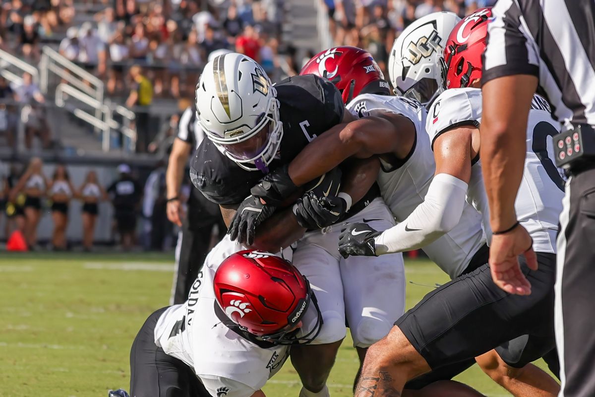 Oct 12, 2024; Orlando, Florida, USA; UCF Knights running back RJ Harvey (7) is tackled during the second quarter against the Cincinnati Bearcats at FBC Mortgage Stadium. Mandatory Credit: Mike Watters-Imagn Images