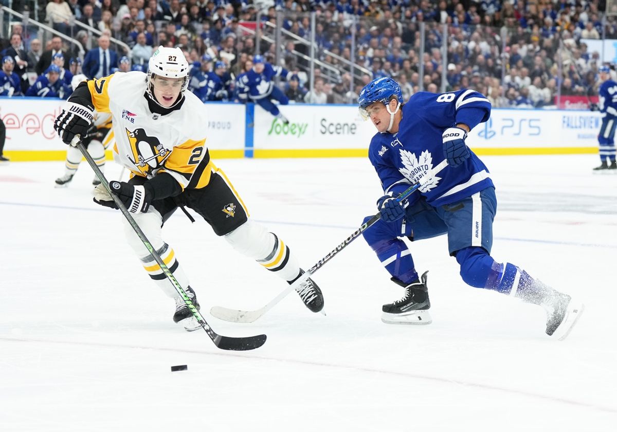 Oct 12, 2024; Toronto, Ontario, CAN; Toronto Maple Leafs right wing William Nylander (88) battles for the puck with Pittsburgh Penguins defenseman Ryan Graves (27) during the first period at Scotiabank Arena. Mandatory Credit: Nick Turchiaro-Imagn Images