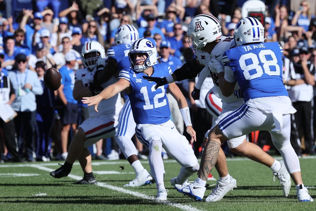 Oct 12, 2024; Provo, Utah, USA; Brigham Young Cougars quarterback Jake Retzlaff (12) pitches the ball against the Arizona Wildcats during the third quarter at LaVell Edwards Stadium. Mandatory Credit: Rob Gray-Imagn Images