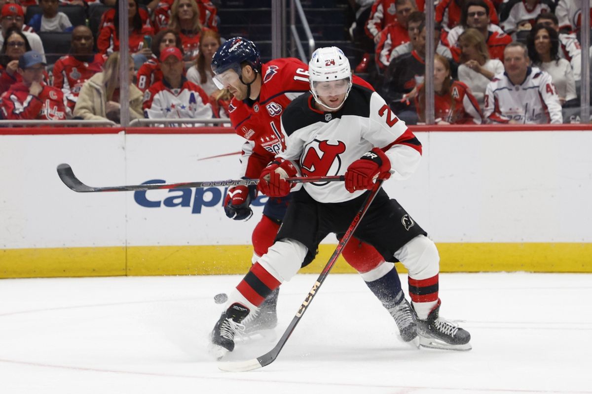 Oct 12, 2024; Washington, District of Columbia, USA; New Jersey Devils defenseman Seamus Casey (24) and Washington Capitals right wing Taylor Raddysh (16) battle for the puck in the first period at Capital One Arena. Mandatory Credit: Geoff Burke-Imagn Images