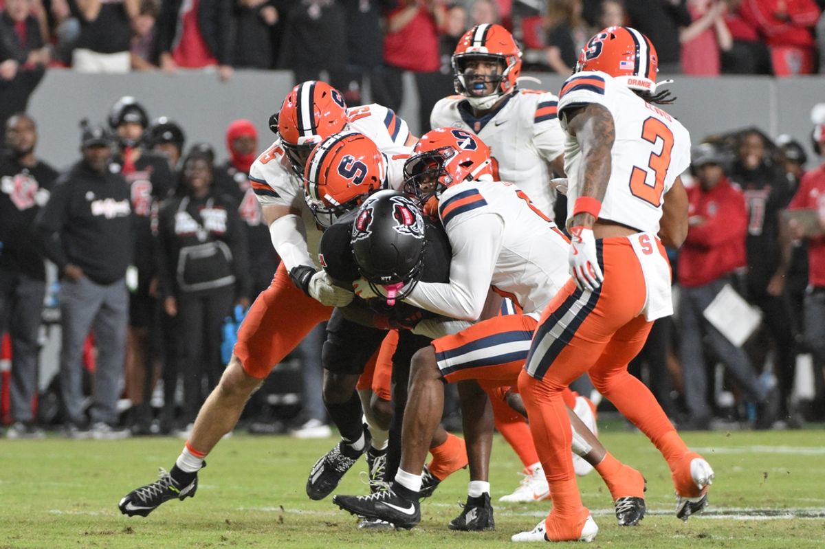 Oct 12, 2024; Raleigh, North Carolina, USA; North Carolina State Wolfpack saftey DK Kaufman (5) is brought down by Syracuse Orange defensive line during the first quarter at Carter-Finley Stadium. Mandatory Credit: Zachary Taft-Imagn Images