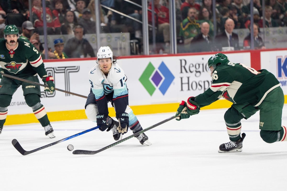 Oct 12, 2024; Saint Paul, Minnesota, USA; Seattle Kraken left wing Brandon Tanev (13) and Minnesota Wild defenseman Jared Spurgeon (46) play the puck in the first period at Xcel Energy Center. Mandatory Credit: Matt Blewett-Imagn Images