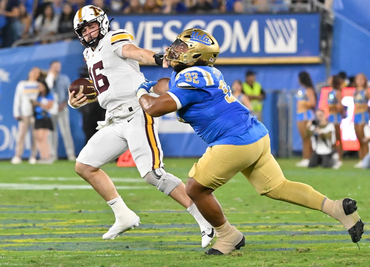 Oct 12, 2024; Pasadena, California, USA; Minnesota Golden Gophers quarterback Max Brosmer (16) stiff arms UCLA Bruins defensive lineman Siale Taupaki (92) during the second quarter at Rose Bowl. Mandatory Credit: Robert Hanashiro-Imagn Images