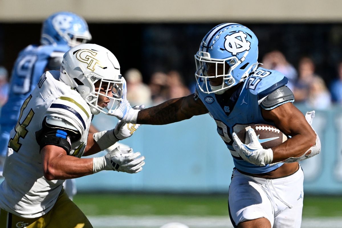 Oct 12, 2024; Chapel Hill, North Carolina, USA;  North Carolina Tar Heels running back Omarion Hampton (28) with the ball as Georgia Tech Yellow Jackets linebacker Kyle Efford (44) defends in the fourth quarter at Kenan Memorial Stadium. Mandatory Credit: Bob Donnan-Imagn Images