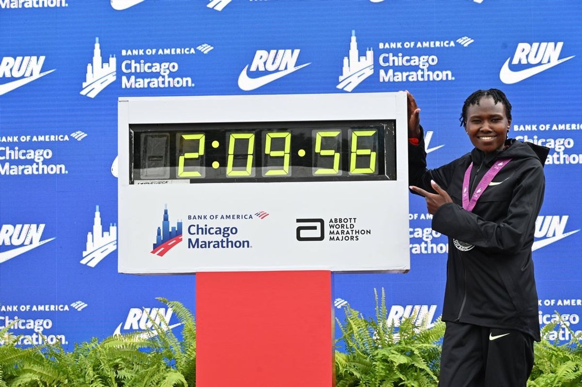 Oct 13, 2024; Chicago, IL, USA; Ruth Chepngetich of Kenya poses for a photo with the time clock after finishing first in the womenís race, setting a new world record at 2:09:56 during the Chicago Marathon at Grant Park. Mandatory Credit: Patrick Gorski-Imagn Images
