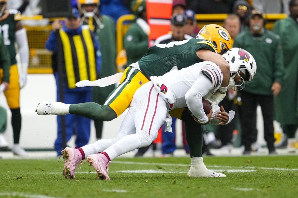 Oct 13, 2024; Green Bay, Wisconsin, USA;  Green Bay Packers safety Evan Williams (33) tackles Arizona Cardinals quarterback Kyler Murray (1) during the second quarter at Lambeau Field. Mandatory Credit: Jeff Hanisch-Imagn Images