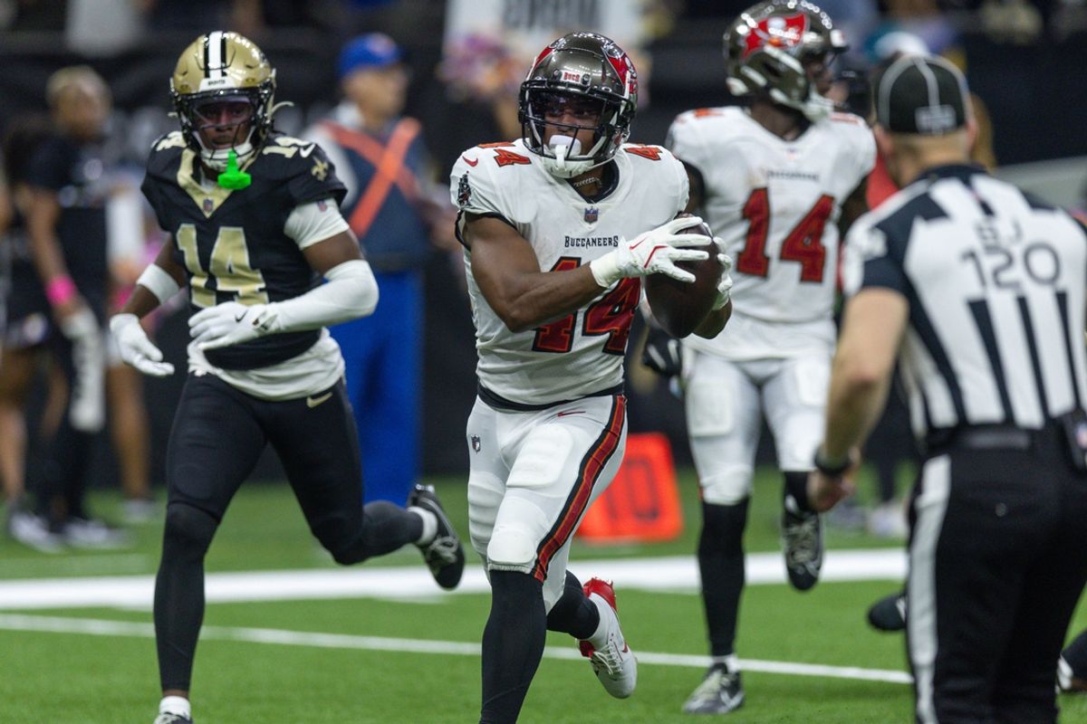 Oct 13, 2024; New Orleans, Louisiana, USA;  Tampa Bay Buccaneers running back Sean Tucker (44) runs away from the tackle of New Orleans Saints safety Johnathan Abram (24) during the first half at Caesars Superdome. Mandatory Credit: Stephen Lew-Imagn Images