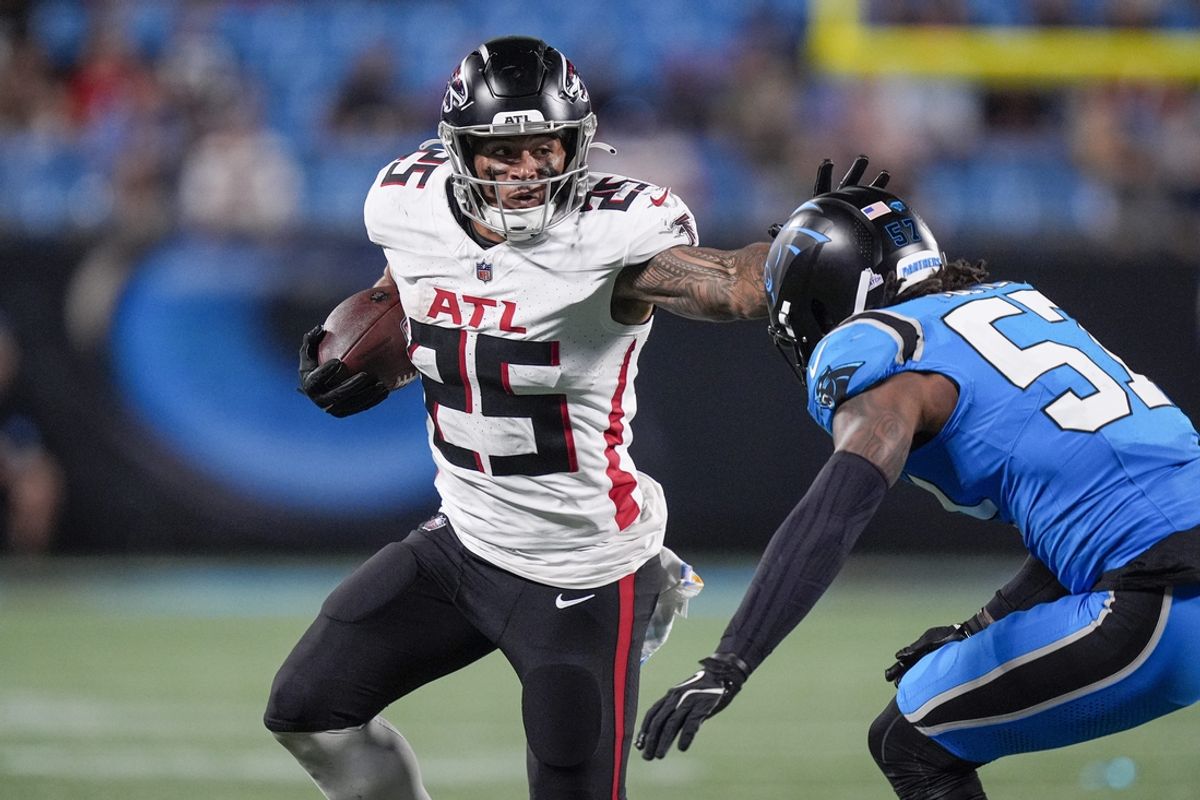 Oct 13, 2024; Charlotte, North Carolina, USA; Atlanta Falcons running back Tyler Allgeier (25) stiff arms Carolina Panthers linebacker Chandler Wooten (57) during the second half at Bank of America Stadium. Mandatory Credit: Jim Dedmon-Imagn Images