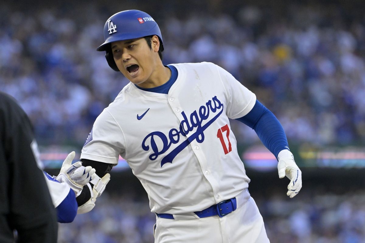 Oct 13, 2024; Los Angeles, California, USA; Los Angeles Dodgers two-way player Shohei Ohtani (17) reacts after hitting a RBI single against the New York Mets in the second inning during game one of the NLCS for the 2024 MLB Playoffs at Dodger Stadium. Mandatory Credit: Jayne Kamin-Oncea-Imagn Images