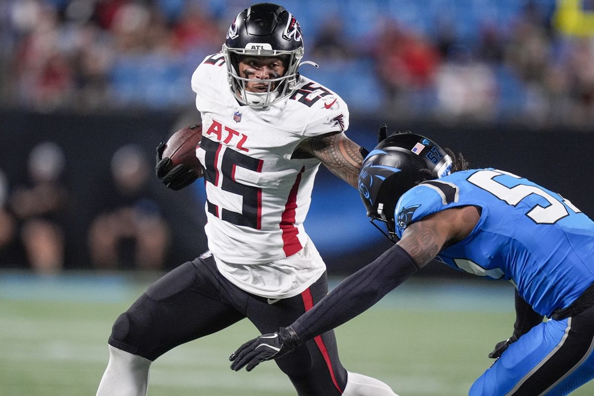 Oct 13, 2024; Charlotte, North Carolina, USA; Atlanta Falcons running back Tyler Allgeier (25) stiff arms Carolina Panthers linebacker Claudin Cherelus (53) during the second half at Bank of America Stadium. Mandatory Credit: Jim Dedmon-Imagn Images