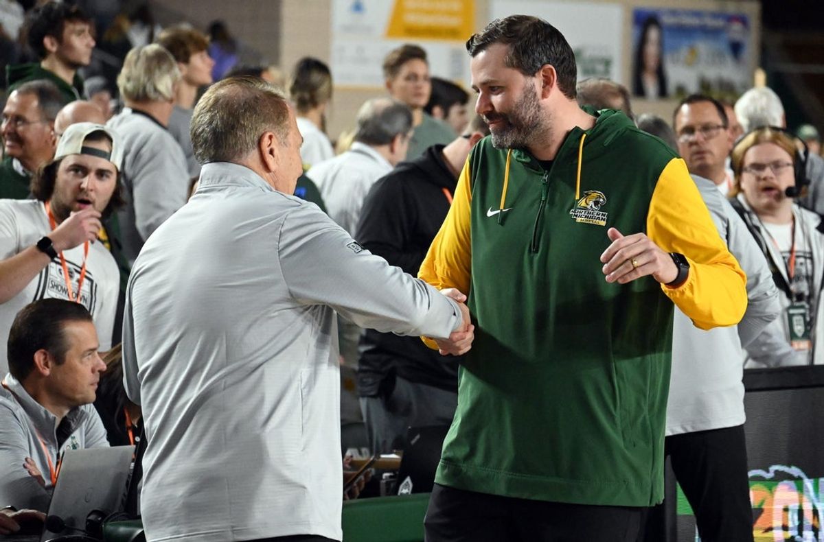 Michigan State men's basketball coach Tom Izzo (left) shakes hands with Northern Michigan coach Matt Majkrzak before the Spartans' exhibition season opener against NMU on Sunday, Oct. 13, in Marquette. Izzo, a 1977 NMU graduate, was also honored with his jersey No. 10 retired during the game.
