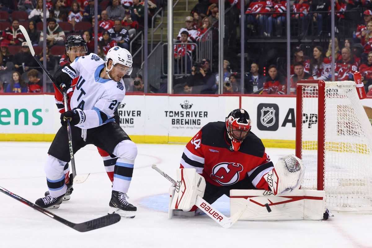 Oct 14, 2024; Newark, New Jersey, USA; New Jersey Devils goaltender Jake Allen (34) makes a save while Utah Hockey Club center Barrett Hayton (27) looks for the rebound during the first period at Prudential Center. Mandatory Credit: Ed Mulholland-Imagn Images