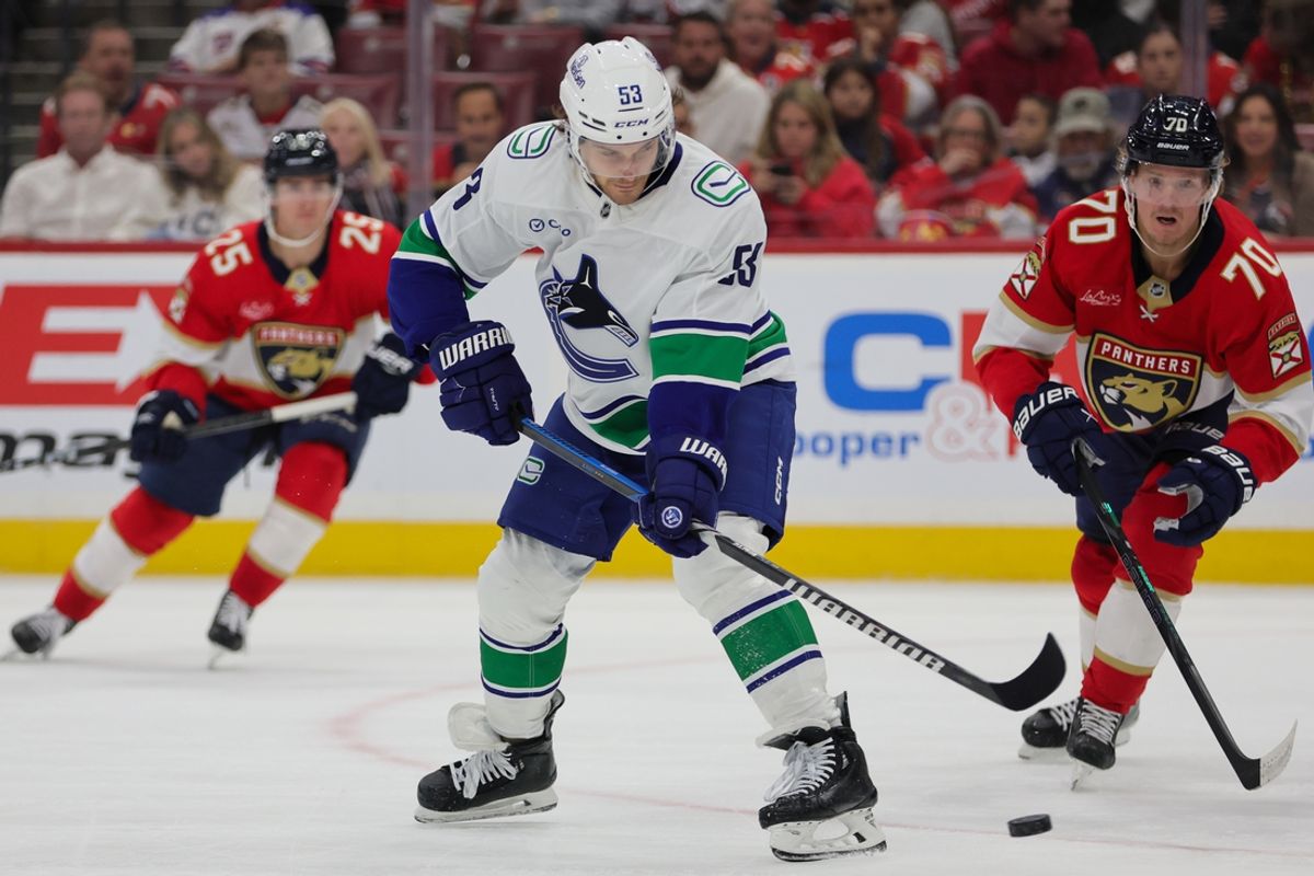 Oct 17, 2024; Sunrise, Florida, USA; Vancouver Canucks center Teddy Blueger (53) shoots the puck against the Florida Panthers during the second period at Amerant Bank Arena. Mandatory Credit: Sam Navarro-Imagn Images