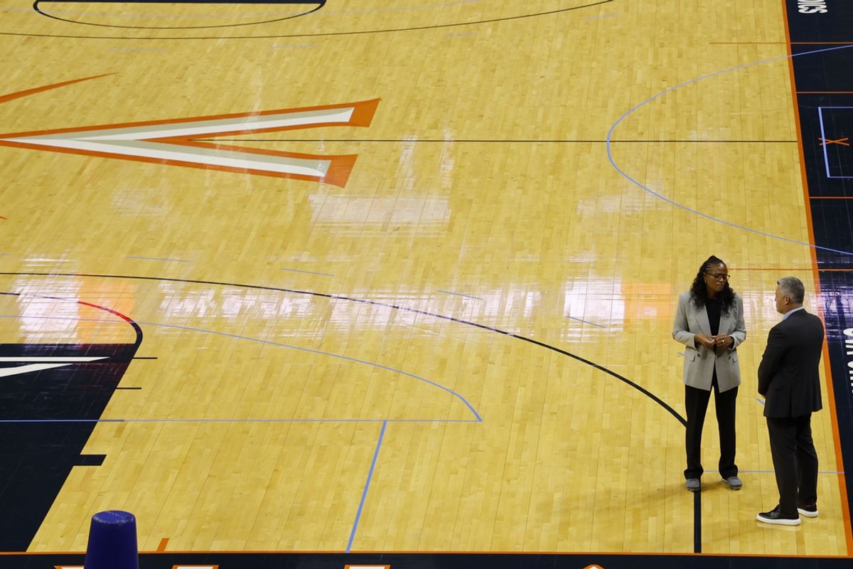 Oct 18, 2024; Charlottesville, VA, US; Virginia Cavaliers head men's basketball coach Tony Bennett (R) and Virginia athletic director Karla Williams (L) talk on the court after a press conference announcing Bennett's immediate retirement at John Paul Jones Arena. Mandatory Credit: Geoff Burke-Imagn Images