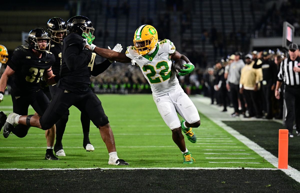 Oct 18, 2024; West Lafayette, Indiana, USA; Oregon Ducks running back Jay Harris (22) strong arms Purdue Boilermakers linebacker Kydran Jenkins (4) to score a touchdown during the second half at Ross-Ade Stadium. Mandatory Credit: Marc Lebryk-Imagn Images