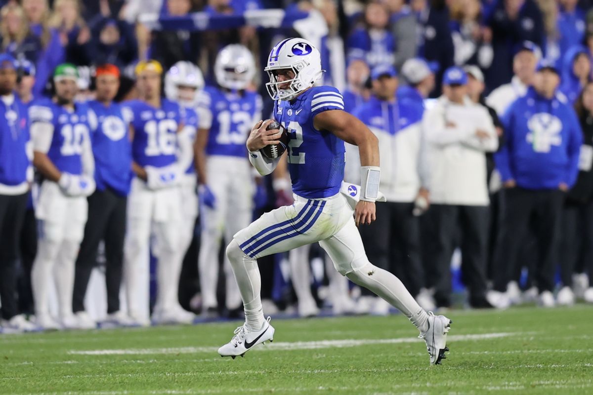 Oct 18, 2024; Provo, Utah, USA; Brigham Young Cougars quarterback Jake Retzlaff (12) runs for a first down against the Oklahoma State Cowboys during the second quarter at LaVell Edwards Stadium. Mandatory Credit: Rob Gray-Imagn Images