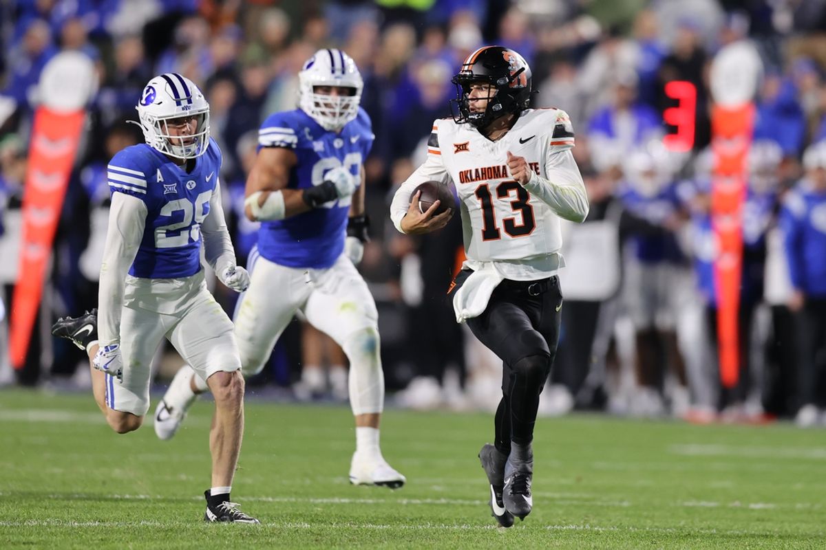 Oct 18, 2024; Provo, Utah, USA; Oklahoma State Cowboys quarterback Garret Rangel (13) runs from Brigham Young Cougars cornerback Jayden Dunlap (29) during the second quarter at LaVell Edwards Stadium. Mandatory Credit: Rob Gray-Imagn Images