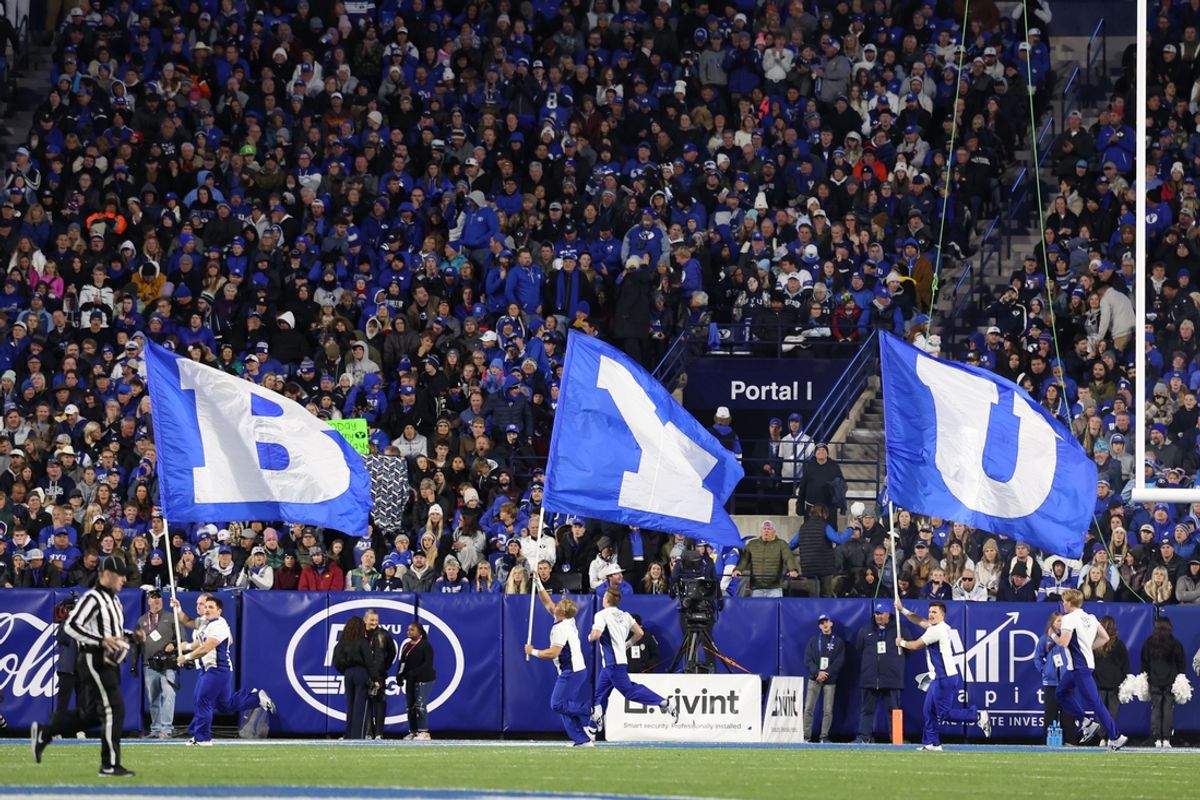 Oct 18, 2024; Provo, Utah, USA; Brigham Young Cougars cheerleaders run with flags after a score against the Oklahoma State Cowboys during the fourth quarter at LaVell Edwards Stadium. Mandatory Credit: Rob Gray-Imagn Images
