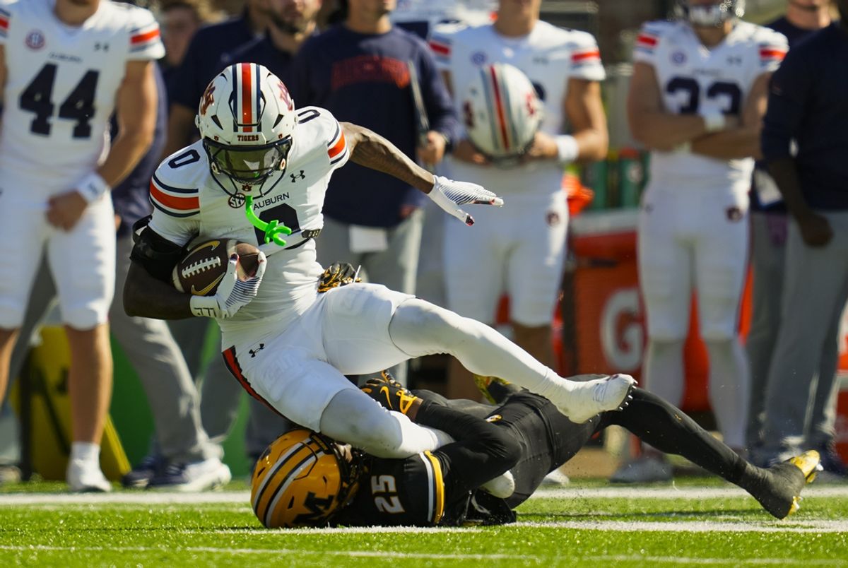 Oct 19, 2024; Columbia, Missouri, USA; Auburn Tigers running back Damari Alston (0) is tackled by Missouri Tigers cornerback Ja'Marion Wayne (25) during the second half at Faurot Field at Memorial Stadium. Mandatory Credit: Jay Biggerstaff-Imagn Images